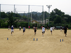 グラウンドでダッシュする男子学生